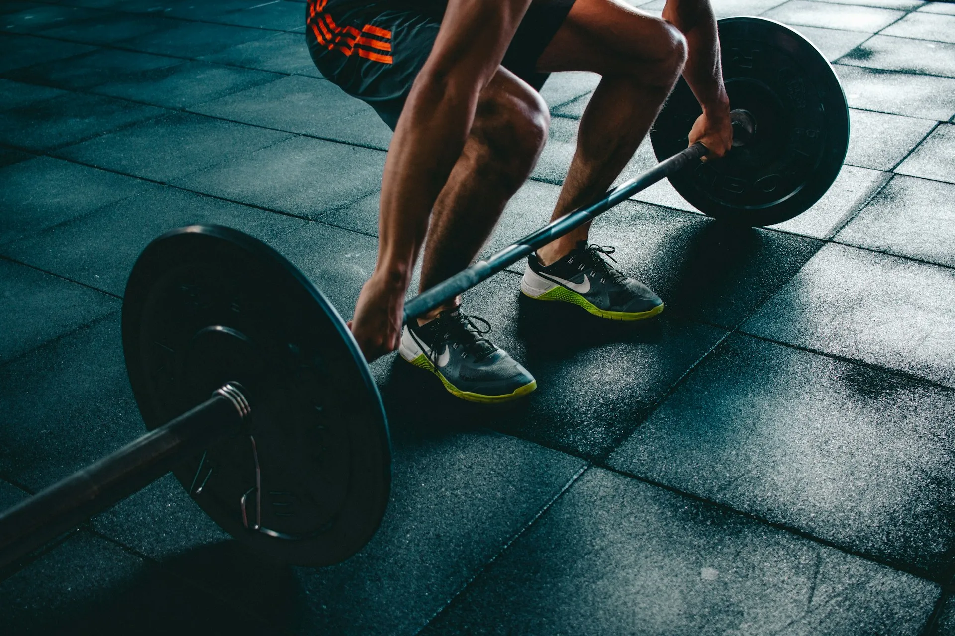 Uomo robusto solleva un bilanciere pesante in palestra